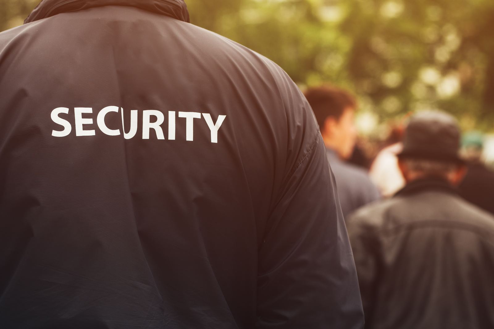 A security officer at an entry point, seen from behind